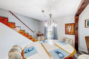 A dining area with a round table, chairs, and a staircase with wooden steps. - Adorable nautical home close to town, W/D, & streaming, dog friendly (Wells)