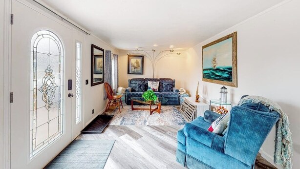 A living room with a sofa, coffee table, and a painting on the wall. - Adorable nautical home close to town, W/D, & streaming, dog friendly (Wells)
