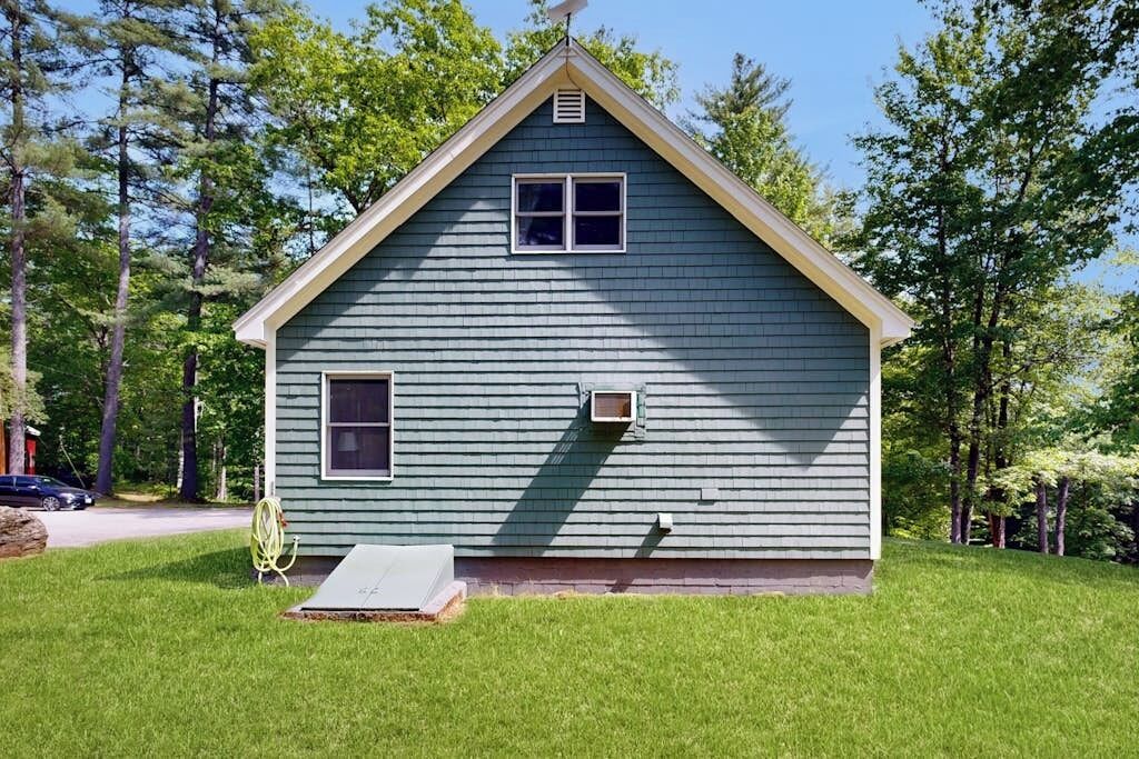 A single-story house with a gabled roof, a small front porch, and a visible chimney.