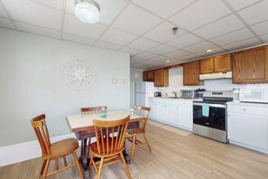 Une cuisine moderne avec des meubles blancs, des chaises en bois et un îlot central.