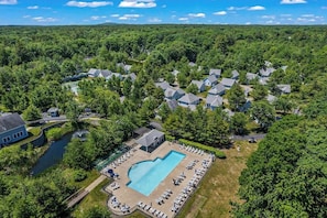 An aerial view of a residential area with houses, a swimming pool, and a small body of water. - Cozy cottage with steps-to-the-pool access, fully equipped kitchen & beach gear (Wells)