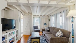 A living room with a television, sofa, and a coffee table. - Quaint Cottage with Lobster Pot, Modern Amenities, and Several Beaches Nearby (Wells)