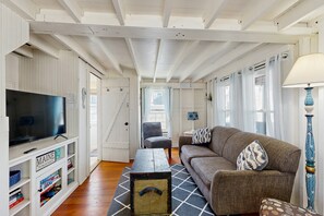 Ein Wohnzimmer mit Fernseher, Sofa und Couchtisch.