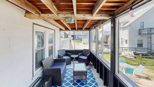 A covered patio with wicker furniture, a small table, and a view of the backyard. - Quaint Cottage with Lobster Pot, Modern Amenities, and Several Beaches Nearby (Wells)