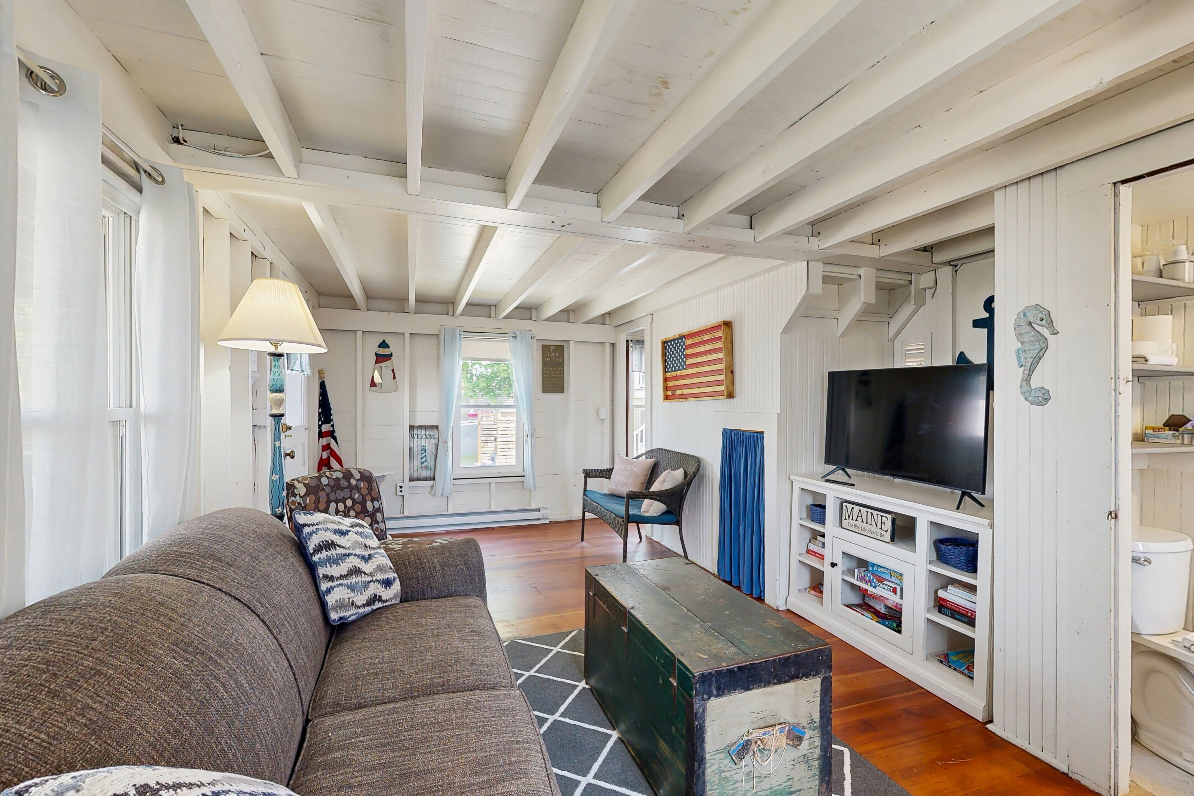 A living room with a sofa, a television, and a bookshelf.