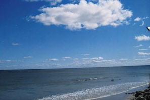 Ein Strand mit klarem Himmel und ruhigem Wasser.
