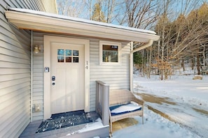 A single-story house with a front door, a small porch with a chair, and a number '14' on the door. - Two-level Townhome with Gas Fireplace, Deck, and Grill - Amazing Location (Bartlett)