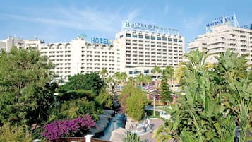 Un hotel con varios pisos, balcones y un cartel que indica que es un hotel.