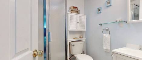Ein Badezimmer mit Toilette, Waschbecken, Spiegel und Schrank.