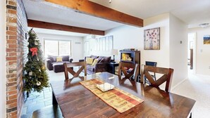 A dining area with a wooden table, chairs, and a Christmas tree. - Snowbird-friendly home with heated pool, sauna, game room, tennis, BBQ, W/D (Bartlett)