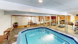 An indoor swimming pool with a tiled edge, exercise equipment, and seating areas. - Comfort, convenience & amenities: close to skiing, hiking & shopping (Bartlett)