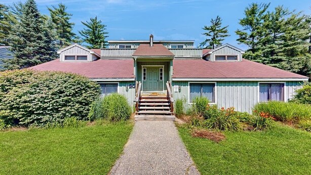 A two-story house with a front entrance, a covered porch, and a gravel driveway. - Comfort, convenience & amenities: close to skiing, hiking & shopping (Bartlett)