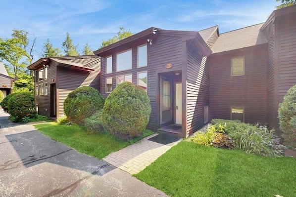 A modern two-story house with a well-maintained lawn and a paved driveway. - Cozy Condo with Shared Pool, High-Speed WiFi, W/D, Partial AC (Bartlett)