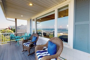 A covered outdoor seating area with wicker furniture and a view of the ocean. - Oceanfront Stunner w/ Kayaks, Beach Gear, Fireplace, Amazing Water Views & Pond (Rye)