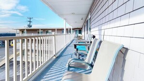 A balcony with a view of the street, a railing, and a row of chairs. - 2nd-floor studio 1 block from the beach with pool, beach access, grills, & W/D (Hampton)