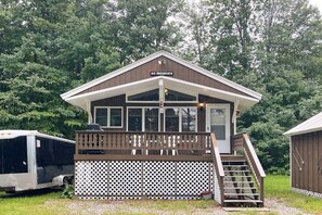 Eine Lodge mit überdachter Terrasse, einer Treppe und einem Schild mit der Aufschrift '60 Brookview'.