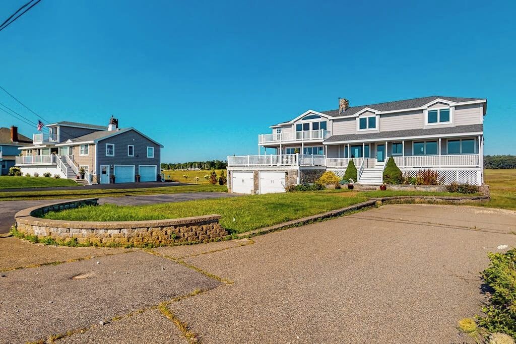 A two-story house with a front porch, a garage, and a small garden area.