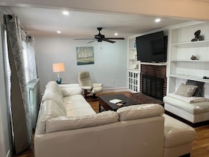 A living room with a sectional sofa, a single armchair, a coffee table, a fireplace, and a ceiling fan. - Bring Fido! Spacious 2 family home 7-bedroom 5 bathroom in charming Chatham.🐶⛱️🛥️ (Chatham)