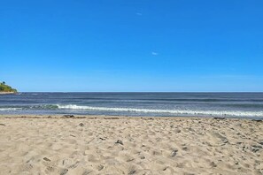 Une plage avec un ciel dégagé et des vagues douces.