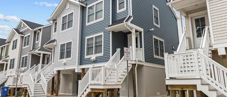 A row of multi-story residential buildings with external staircases and a 'NO PARKING FIRE LANE' sign.