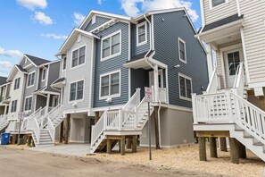 A row of multi-story residential buildings with external staircases and a 'NO PARKING FIRE LANE' sign.