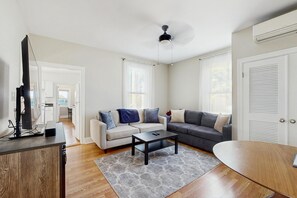 A modern living room with a sofa, coffee table, and TV stand.