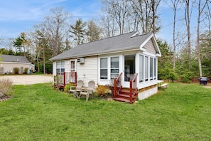 A single-story house with a front porch, a small deck, and a lawn.