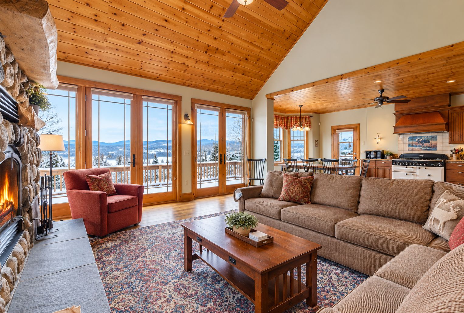 A spacious living room with a fireplace, large windows, and a view of the outdoors.