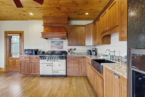 A kitchen with wooden cabinets, a stove, a sink, and a refrigerator.