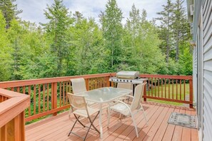 A deck with a grill, a glass table, and chairs. - Dog-friendly country home w/ jetted tub, backyard & grill (Franconia)