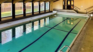 Ein Schwimmbecken mit klarem Wasser, markierten Bahnen und einer Poolleiter.