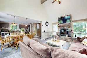Amplia sala de estar con chimenea, comedor y cocina.