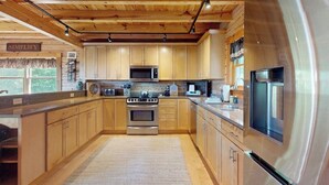 Una cocina moderna con armarios de madera, electrodomésticos de acero inoxidable y un cartel que dice 'SIMPLIFY'.