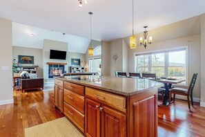Un'ampia cucina con pensili in legno, un'isola grande e illuminazione a sospensione.