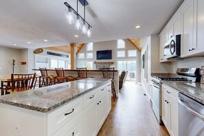 A spacious kitchen with granite countertops, white cabinetry, and a large island. - Stunning Mountain View Home: In the heart of outdoor entertainment (Bartlett)