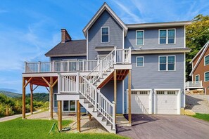 A two-story house with a covered deck and a staircase leading to the second floor. - Stunning Mountain View Home: In the heart of outdoor entertainment (Bartlett)