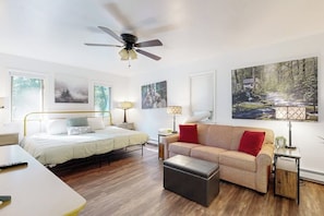 Une chambre à coucher moderne, équipée d’un lit, d’un canapé, d’un bureau et d’un ventilateur de plafond.