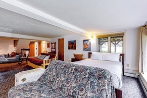 A bedroom with a bed, a sofa, a chair, and a window.