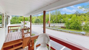 A covered porch with a view of a road and greenery. - Charming and casual motel in a great location with shared resort amenities (Lincoln)