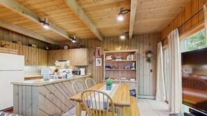 Ein gemütliches Blockhaus-Interieur mit einer Holztischlerei, einer Küche und einem Fernseher.