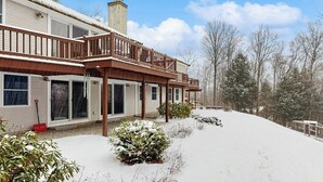 A two-story house with a covered porch and a snow-covered yard. - Serene Dog Friendly Home:  near skiing, hiking, Storyland, Shopping & dining (Glen)