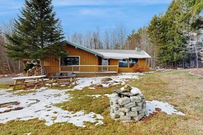 A lodge with a wooden exterior, a stone fireplace, and a picnic table area. - Mountainview Home w/ large yard, stunning views, close to skiing, hiking & town (Bethlehem)