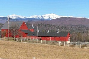 A red building with a white fence in front, a snow-capped mountain in the background, and a clear sky. - Mountainview Home w/ large yard, stunning views, close to skiing, hiking & town (Bethlehem)