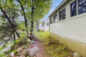 A row of single-story cabins with a natural, wooded setting.