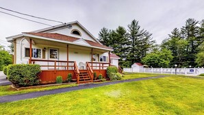 A single-story house with a front porch, a small front yard, and a white picket fence. - Charming and casual motel in a great location with shared resort amenities (Lincoln)