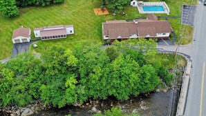 Zona residencial con dos casas, una piscina y un puente.