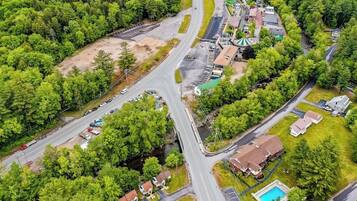An aerial view of a residential area with multiple roads, houses, and a swimming pool.