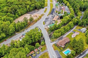 An aerial view of a residential area with multiple roads, houses, and a swimming pool.