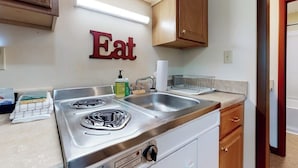A kitchen with a stove, sink, and wooden cabinets. - Charming and causal motel in a great location with shared resort amenities (Lincoln)
