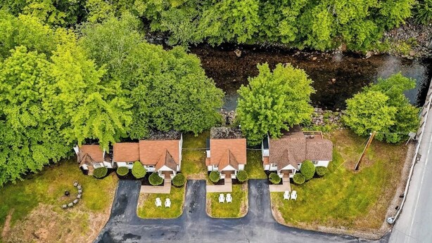 Un quartiere residenziale con case, un vialetto e un piccolo corso d'acqua.